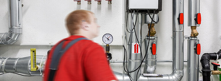 Bild eines Mitarbeiters bei der Kontrolle in einem Heizungskeller